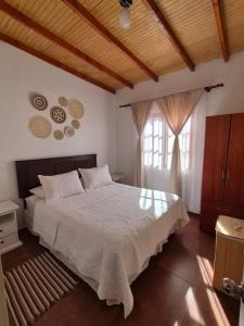 a bedroom with a large bed and a window at Cabañas La Marca in San Pedro de Atacama