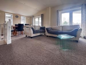 a living room with two couches and a table at Royal Retreat in Wisbech