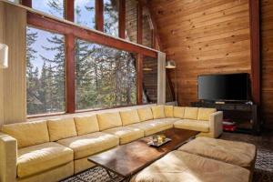 a living room with a couch and a large window at Snowball House in Government Camp