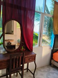 ein Spiegel auf einer Kommode neben einem Fenster in der Unterkunft Fiesta Zipolite in Zipolite