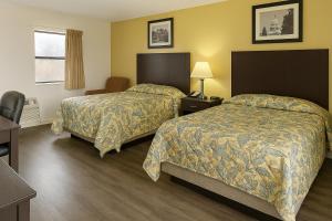 a hotel room with two beds and a desk at Country Host Inn in Franklin