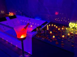 a purple room with a bar with a bottle and glasses at Cazalegas Sky Spa in Cazalegas