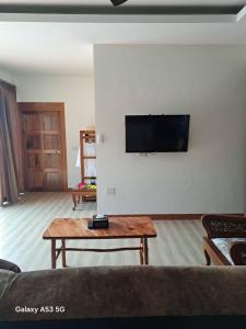 a living room with a couch and a tv on a wall at Bulan Villa Koh Yao Noi in Ban Laem Sai