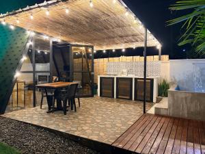 a patio with a table and a kitchen with lights at Cabaña in Sopetrán +4 photos