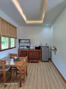 a kitchen with a wooden table and a refrigerator at Bulan Villa Koh Yao Noi in Ban Laem Sai