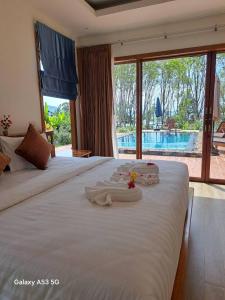 a bedroom with a large white bed with towels on it at Bulan Villa Koh Yao Noi in Ban Laem Sai +61 photos