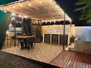 a patio with a table and a kitchen with lights at Cabaña in Sopetrán