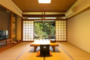 a room with a table and a tv in it at 霧島花紫 in Kirishima