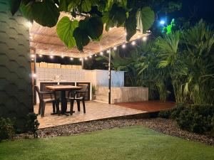 a patio with a table and chairs at night at Cabaña in Sopetrán