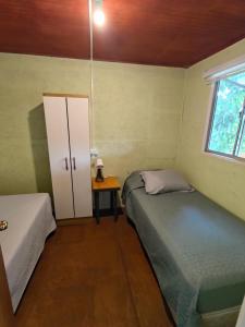 a small bedroom with two beds and a window at Los Tatas in Colbún