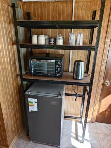 a kitchen with a microwave and a refrigerator and a table at Los Tatas in Colbún +10 photos