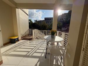 a balcony with a white table and chairs on it at 1 BR Love Cube in Kingston