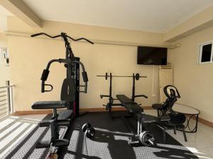 a gym with three exercise bikes and a flat screen tv at 1 BR Love Cube in Kingston +1 photo