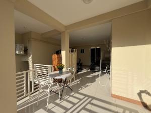 a room with a table and chairs on a balcony at 1 BR Love Cube in Kingston