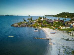 an aerial view of a beach with boats in the water at Pousada Praia do Calixto in São Francisco do Sul