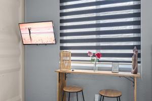 a table with two stools in front of a window at Cozy 1BR Beachside Apartment Entre Olas in Vega Baja