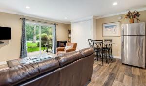 a living room with a leather couch and a refrigerator at First-Floor Downtown Bend Condo in Bend