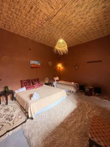 a bedroom with a large bed and a chandelier at Dar Talmoudi ,Traditional Riad, Local Food, Camel , Desert Excursions in Tagounite +69 photos