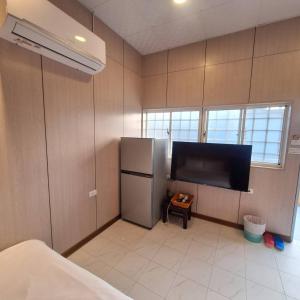 a kitchen with a refrigerator and a flat screen tv at Nanwan Muyang 168 Homestay in Hengchun South Gate +13 photos