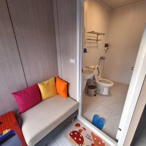a small bathroom with a bench with colorful pillows at Nanwan Muyang 168 Homestay in Hengchun South Gate