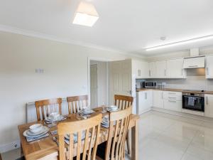 a kitchen and dining room with a wooden table and chairs at Dawson Park 10 - Uk12669 in Mablethorpe