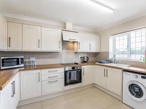a kitchen with white cabinets and a washer and dryer at Dawson Park 10 - Uk12669 in Mablethorpe +15 photos