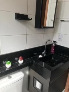 a bathroom with a black counter top with a sink at Apto completo próximo a Johnson e Johnson e Dutra in São José dos Campos +17 photos