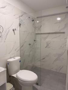 a bathroom with a toilet and a glass shower at Casa Calina Hotel in Caucasia +25 photos