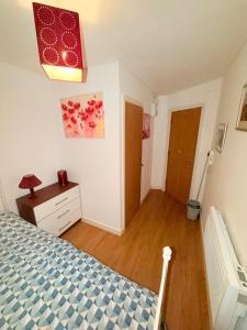 a bedroom with a bed and a wooden floor at Quick Stop Double Bed Flat - Bradford City Center in Bradford