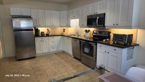 a kitchen with white cabinets and stainless steel appliances at Spacious 2 BR, 3 beds, sleeps 6, kitchen, laundry in Richmond Hill
