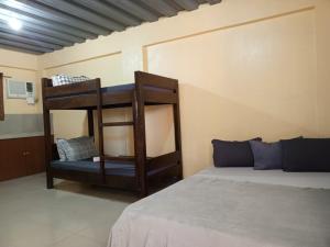 a bunk bed in a room with a bed gmaxwell gmaxwell gmaxwell gmaxwellythonythonython at Casa-de Aplaya in Gasan