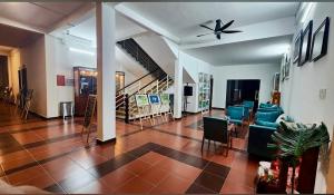 a living room with blue chairs and a ceiling fan at Wildbird Hotel in Tràm Chim