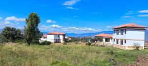 a group of houses in a field with mountains in the background at Casas Villa de Leyva in Villa de Leyva