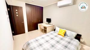 a bedroom with a bed and a desk with a computer at Snow Sapporo cozy house in Sapporo