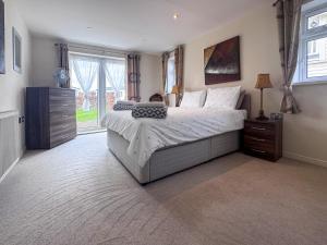 a bedroom with a large bed and a window at Royal Retreat in Wisbech +5 photos