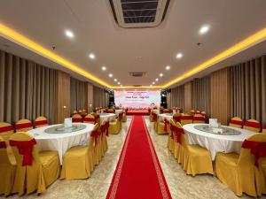 a banquet hall with tables and chairs and a red carpet at Marina Cua Lo Hotel in Cửa Lô +18 photos