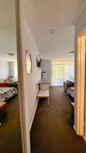 a room with a room with two beds and a table at Mandurah Coastal Studio - Pool Outlook in Mandurah +29 photos