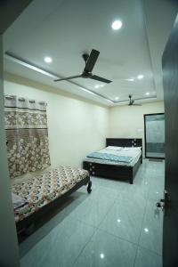 a room with two beds and a flat screen tv at Sri RENUKA VSR Residency in Avanigadda