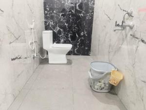 a bathroom with a toilet and a bucket at Sri RENUKA VSR Residency in Avanigadda