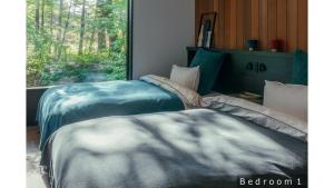 a bedroom with two beds and a window at La Maison Karuizawa in Karuizawa
