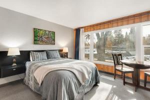 a bedroom with a bed and a table and a window at Riverfront Studio with Trail access in Bend