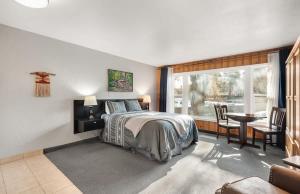 a bedroom with a bed and a table and a window at Riverfront Studio with Trail access in Bend