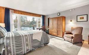 a bedroom with a bed and a chair and a window at Riverfront Studio with Trail access in Bend +23 photos