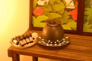 a vase sitting on a table next to a plate of cookies at Kerama Terrace in Tokashiki