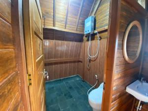 a small bathroom with a toilet and a sink at Pondok DG and Spa in Munduk +69 photos