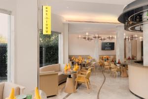 a restaurant with tables and chairs and a bar at Hotel Gwalior Regency, a member of Radisson Individuals in Gwalior