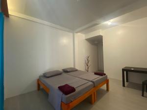 a bedroom with a bed in a white room at Be My Guest Hostel in Panglao Island
