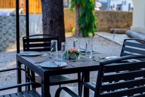 a black table with plates and glasses on it at Cathedral Hotel Zanzibar in Zanzibar City