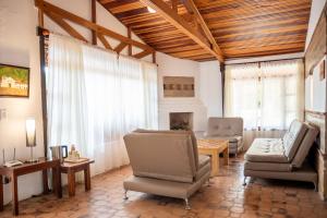 a living room with chairs and a couch and a fireplace at Hacienda Cascanueces in Villa de Leyva