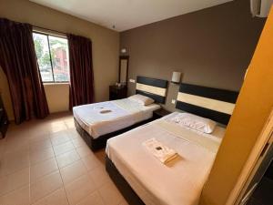 a hotel room with two beds and a window at Swing & Pillows - Skudai Johor in Skudai
